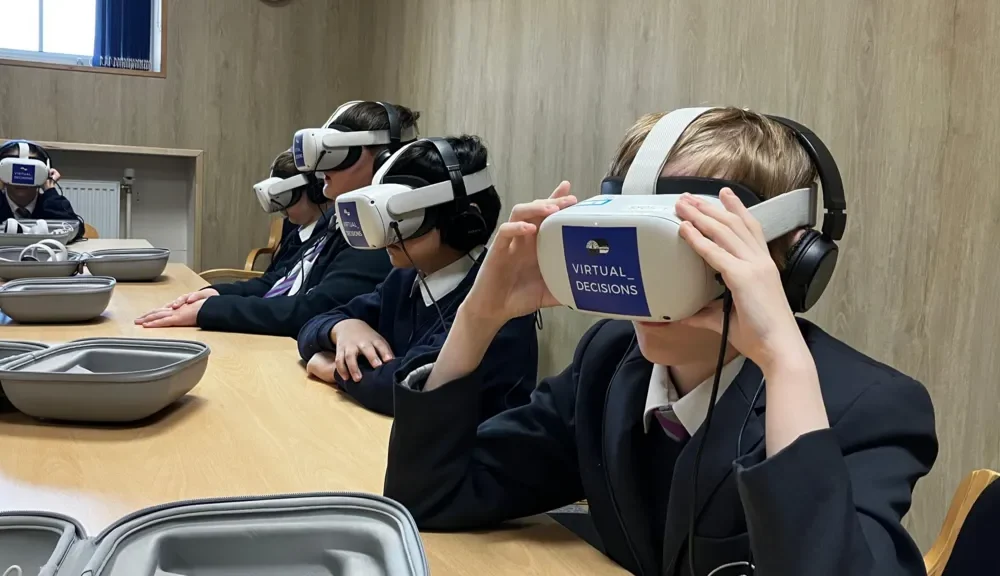 Police officers supervising students using virtual reality gear during an interactive safety session.